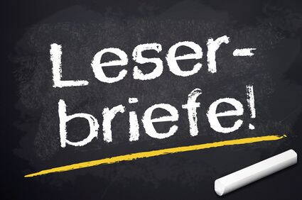 Kreidetafel mit der weißen Aufschrift „Leserbriefe!“ und einem gelben Unterstrich neben einem Stück Kreide