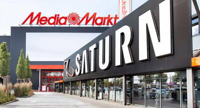 Eingang eines großen Elektronikmarkts mit auffälligem SATURN-Schriftzug im Vordergrund und MediaMarkt-Logo auf dem Gebäudedach im Hintergrund