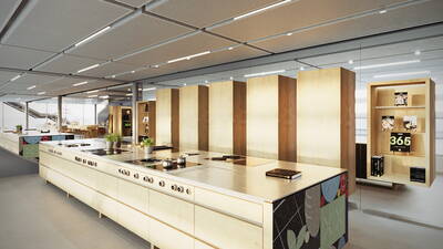 Modern gestaltete Showküche mit langen Kochinseln aus hellem Holz, Induktionskochfeldern, frischen Kräutertöpfen und beleuchteten Regalen mit Kochbüchern in einem großzügigen, lichtdurchfluteten Raum