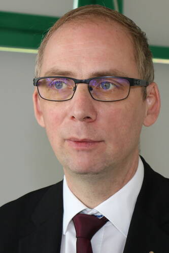 Mittelalterlicher Mann mit Brille und Anzug blickt nachdenklich zur Seite