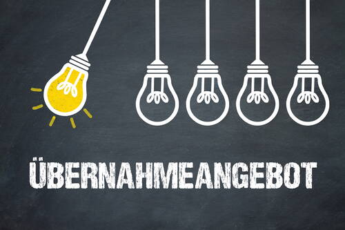 Leuchtende gelbe Glühbirne stößt drei nicht leuchtende weiße Glühbirnen an, darunter in Weiß das Wort „ÜBERNAHMEANGEBOT“ auf dunkler Tafeloberfläche