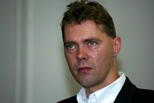 Mittelalter Mann im Anzug blickt ernst und konzentriert vor neutralem Hintergrund in die Ferne