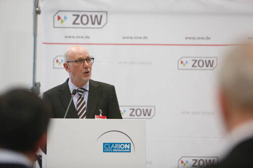 Älterer Mann im Anzug spricht am Rednerpult der Messe ZOW vor Publikum in einem Konferenzsaal
