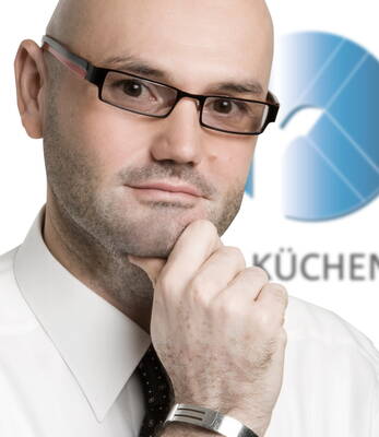 Nachdenklicher Geschäftsmann mit Brille und Hemd stützt das Kinn mit der Hand vor einem unscharfen Firmenlogo im Hintergrund
