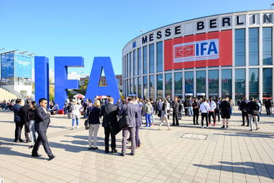 Menschenmenge vor dem Eingang der Messe Berlin mit riesigen blauen IFA-Buchstaben und rotem IFA-Banner an der Glasfassade bei sonnigem Wetter