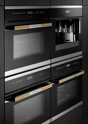 In eine schwarze Küchenfront integrierte Einbaugeräte mit zwei Backöfen, einem Dampfgarer und einer Kaffeemaschine in einheitlichem, modernem Design