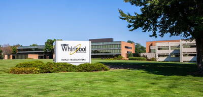 Modernes Bürogebäude mit Whirlpool-Logo und der Beschriftung „World Headquarters“ auf einem Schild vor einer gepflegten Rasenfläche im Sonnenschein