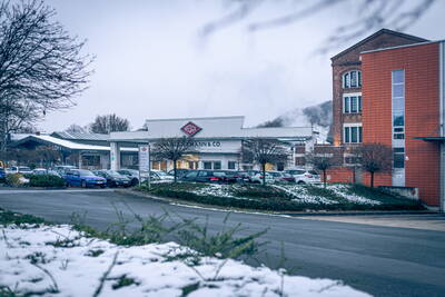Industriestandort mit Wesco-Gebäude, parkenden Autos und leicht verschneiter Landschaft an einem trüben Wintertag