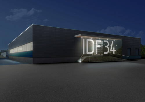Modernes Industriegebäude bei Nacht mit beleuchtetem Glas-Eingang und großer Aufschrift „IDF34“ auf der Frontfassade