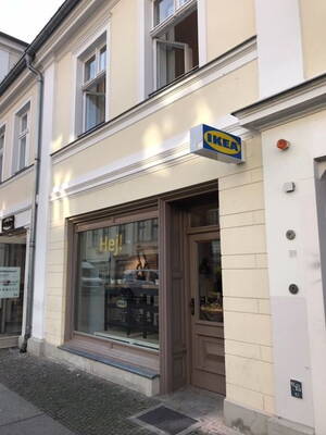 Kleines IKEA-Geschäft im Erdgeschoss eines hellen Altbauhauses mit Schaufenster und seitlichem Eingang an einer ruhigen Stadtstraße