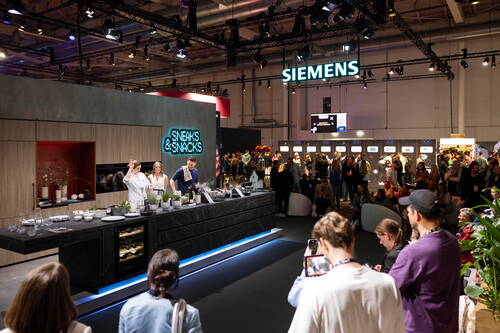 Live-Kochshow an einer modernen Siemens-Messetheke, bei der ein Kochteam vor großem Publikum Gerichte zubereitet und präsentiert