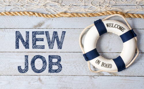 Rettungsring mit Aufschrift „Welcome on Board“ neben dem Schriftzug „New Job“ auf hellen Holzplanken mit maritimen Seilen im Hintergrund