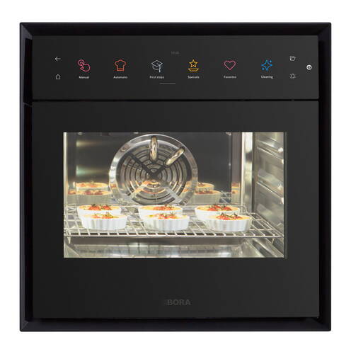 Moderner Einbaubackofen mit Touchdisplay, in dem mehrere kleine Auflaufformen auf einem Rost gebacken werden