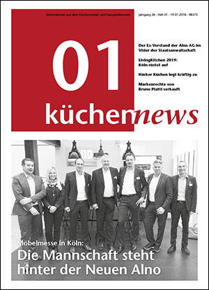 Geschäftsmannschaft in Anzügen posiert lächelnd vor einem Messestand auf dem Titelblatt der Fachzeitschrift „küchennews“ mit Schlagzeile zur Neuen Alno
