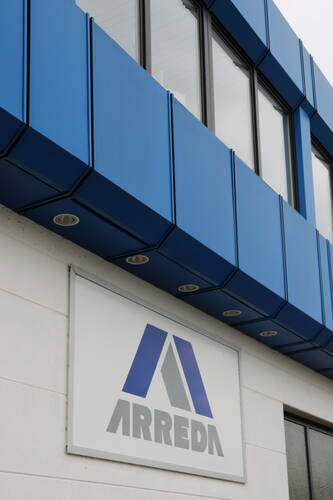 Außenfassade eines modernen Gebäudes mit blauen Paneelen und großem Arreda-Firmenschild an der Wand