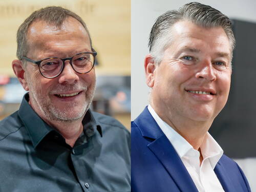 Zwei lächelnde Männer im Porträt nebeneinander, links mit Brille und schwarzem Hemd vor warmer Holzkulisse, rechts im blauen Anzug mit weißem Hemd vor modernem, hellen Hintergrund.