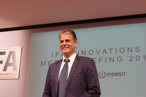 Lächelnder Sprecher im Anzug auf einer IFA-Innovations-Pressekonferenz vor einer Präsentationsleinwand