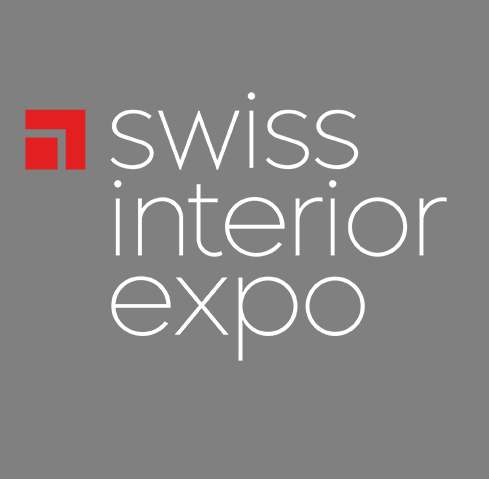 Logo der „Swiss Interior Expo“ mit weißer Typografie auf grauem Hintergrund und rotem geometrischem Symbol oben links