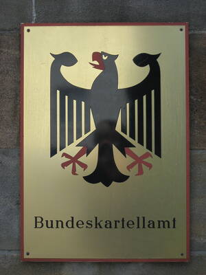 Metallschild an einer Steinwand mit Bundesadler und der Aufschrift „Bundeskartellamt“