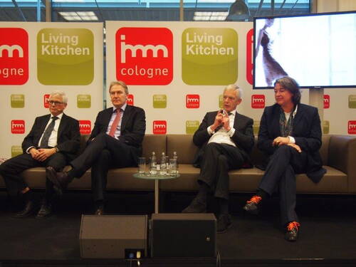 Vier Panelteilnehmer sitzen auf einer Bühne vor imm cologne und Living Kitchen Logos und diskutieren gemeinsam auf einem Sofa während einer Messeveranstaltung.