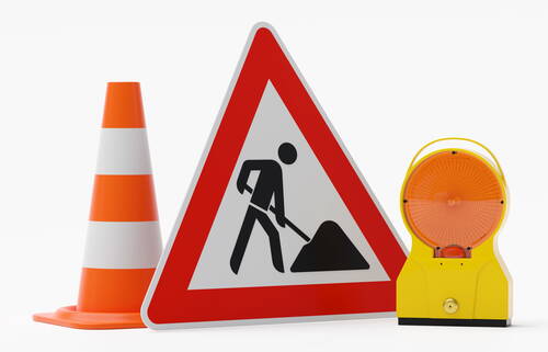 Verkehrswarnausrüstung mit Baustellenschild, orange-weißem Leitkegel und gelber Warnleuchte auf weißem Hintergrund