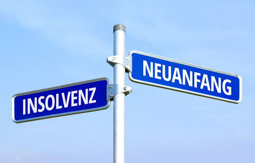 Wegweiser mit den blauen Straßenschildern „Insolvenz“ und „Neuanfang“, die in entgegengesetzte Richtungen zeigen