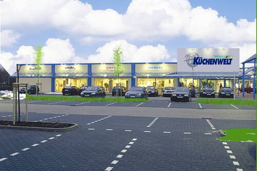 Modernes Küchenstudio „Meyerhoff Küchenwelt“ mit beleuchteter Fassade, mehreren geparkten Autos und einem fast leeren Parkplatz im Vordergrund unter blauem Himmel mit Wolken