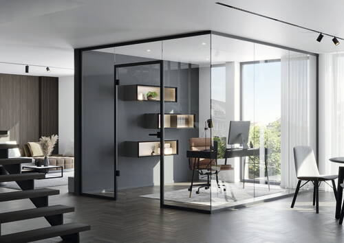 Modernes Homeoffice in gläserner Raum-in-Raum-Lösung mit Schreibtisch, Designerstuhl und beleuchteten Wandregalen vor bodentiefen Fenstern.