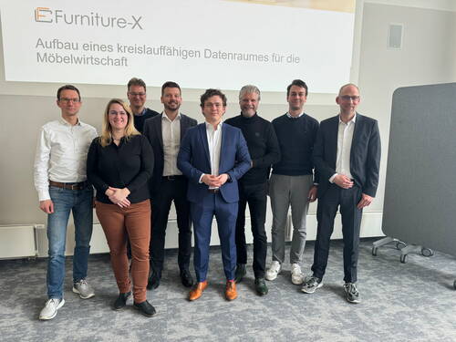 Achtköpfiges Projektteam steht im Konferenzraum vor einer Präsentationsfolie zum Aufbau eines kreislauffähigen Datenraums für die Möbelwirtschaft
