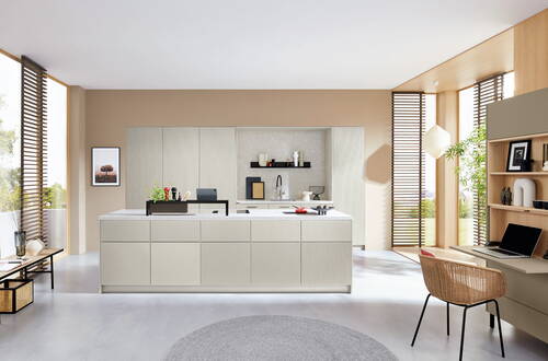 Helle moderne Wohnküche mit großer Kochinsel, deckenhohen Schränken, bodentiefen Fenstern mit Holzlamellen und integriertem Homeoffice-Bereich mit Schreibtisch und Korbstuhl