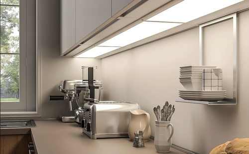 Modern eingerichtete Küchenzeile mit Edelstahl-Toaster, Espressomaschine, Keramikkrügen und ordentlich gestapeltem Geschirr unter beleuchteten Hängeschränken.