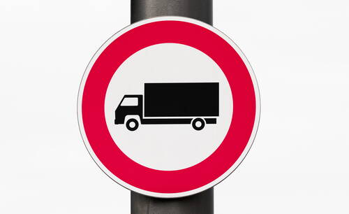 Rundes Verkehrsschild mit rotem Rand und Lkw-Symbol, das ein Durchfahrtsverbot für Lastkraftwagen anzeigt