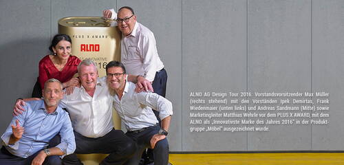 Fünf ALNO-Führungskräfte posieren lächelnd in legerer Kleidung neben einem großen Plus X Award, der die Auszeichnung als „Innovativste Marke des Jahres 2016“ in der Produktgruppe Möbel hervorhebt.