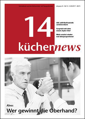 Älterer Mann im Anzug ringt konzentriert beim Armdrücken mit einem unscharf im Vordergrund sitzenden Gegenüber in einem modernen Büro.